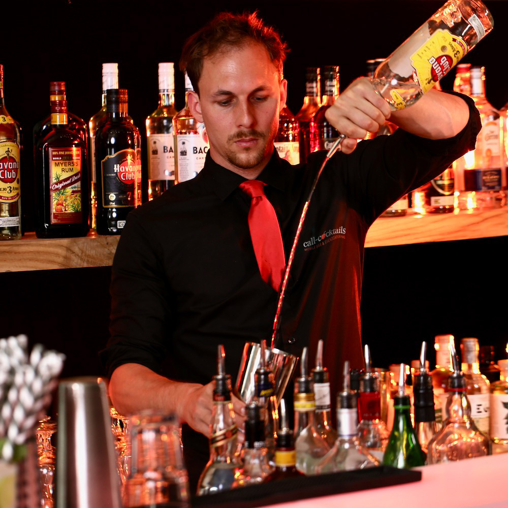 Barkeeper mieten schenkt aus einer Flasche Havana Club Rum in Shaker ein